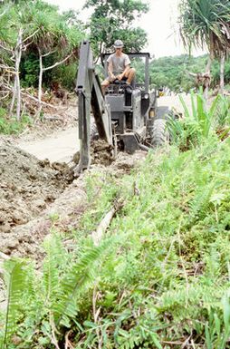 Equipment Operator 2nd Class Emil A. Norby uses a backhoe to dig a waterline on the island of Yap. Norby, a U.S. Navy construction battalion member, is part of a Civic Action Team deployed to the island to aid villagers with construction projects and offer vocational training