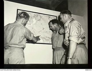 Cairo, Egypt. c. 1944. RAAF ground crew who are being repatriated from the Middle East after long service overseas, study a wall map and speculate where they will serve in the South West Pacific ..