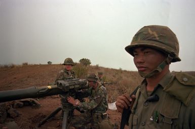 Sergeant Vincente Cruz, section chief, Combat Support Company, 1ST Battalion, 35th Infantry, 25th Infantry Division, observes opposing force positions as his tube-launched, optically-tracked, wire-guided (TOW) misslie squad set up thier weapon. They are t