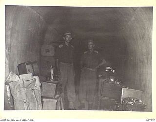 RABAUL, NEW BRITAIN. 1945-10-09. MEMBERS OF 33 FIELD SECURITY SECTION, 11 DIVISION IN A CAVE NEAR DIVISIONAL HEADQUARTERS WITH JAPANESE EQUIPMENT COLLECTED FOR MILITARY HISTORY SECTION