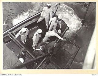 AT SEA OFF RABAUL, NEW BRITAIN. 1945-09-06. GENERAL H. IMAMURA, COMMANDER EIGHTH AREA ARMY, STEPPING FROM THE MOTOR-CUTTER ONTO THE GANGWAY OF THE AIRCRAFT CARRIER HMS GLORY TO FORMALLY SURRENDER ..