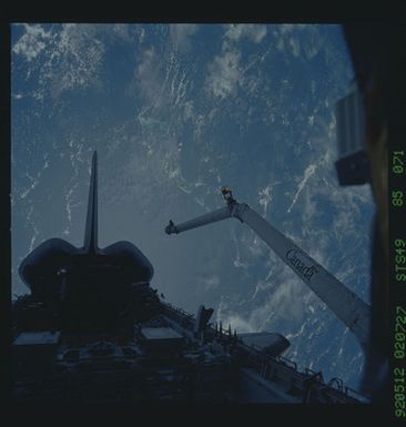 S49-85-071 - STS-049 - Dark views of RMS arm over payload bay