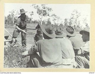 YAKAMUL, NEW GUINEA. 1945-01-09. NX122980 CAPTAIN A.J. MARSHALL, THE ONE ARMED OFFICER IN CHARGE, "JOCK FORCE" AND A MEMBER OF THE 2/2ND INFANTRY BATTALION LECTURING HIS MEN ON THE NEED FOR ..