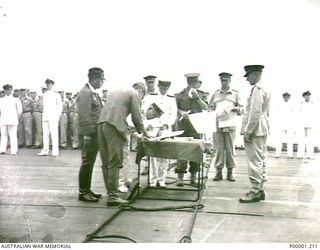 NEW BRITAIN, 1945-09-06. VICE ADMIRAL JINICHI KUSAKA, COMMANDER JAPANESE SOUTHEAST AREA FLEET, SIGNING THE INSTRUMENT OF SURRENDER ON BOARD HMS GLORY OFF RABAUL. (RNZAF OFFICIAL PHOTOGRAPH.)