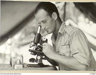 POTSDAM, NEW GUINEA. 1944-09-03. VX77933 SERGEANT R.J. BARNETT CHECKING A BLOOD SMEAR FOR MALARIA IN THE PATHOLOGICAL LABORATORY OF THE 2/15TH FIELD AMBULANCE