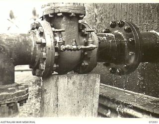 MILNE BAY, NEW GUINEA. 1944-04-04. BY PASS VALVES POSITIONED ON A FUEL LINE AT THE 2ND AUSTRALIAN BULK PETROLEUM STORAGE COMPANY TO RELEASE PRESSURES GREATER THAN 40 POUNDS PER SQUARE INCH INTO A ..