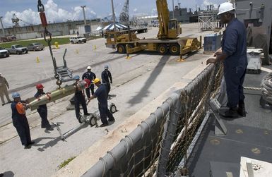 U.S. Navy Sailors assigned to the Arleigh Burke Class Guided Missile Destroyer USS HOPPER (DDG 70), crane a torpedo to the pier during a port visit to Guam on Sep. 5, 2006. The HOPPER is on a scheduled deployment in support of Maritime Security Operations and the Global War on Terrorism.(U.S. Navy photo by Mass Communication SPECIALIST Second Class John L. Beeman) (Released)