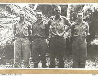 HUON PENINSULA, NEW GUINEA. 1944-01-14. PERSONNEL OF A BRANCH, HEADQUARTERS 9TH DIVISION OUTSIDE THEIR OFFICES DURING THE LAE OPERATIONS. LEFT TO RIGHT: NX58583 PRIVATE (PTE) W. M. MULVANY; VX2167 ..