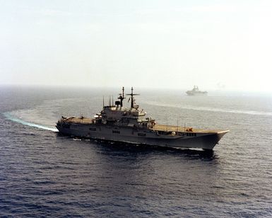 A starboard bow view of the Italian light aircraft carrier ITS GIUSEPPE GARIBALDI (C-551) underway during the NATO Southern Region exercise DRAGON HAMMER '90. Following behind the GARIBALDI is the amphibious assault ship USS SAIPAN (LHA 2)