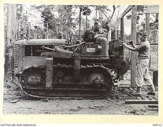 YALU AREA, NEW GUINEA, 1945-07-30. SAPPER N. NEEMS, TRACTOR OPERATOR (1), AND SERGEANT C.L. PRITCHARD, TRANSPORT SERGEANT (2), MEMBERS OF 2/1 FORESTRY COMPANY, ROYAL AUSTRALIAN ENGINEERS, WORKING ..