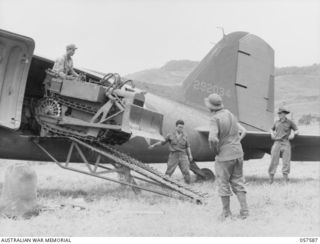 KAIAPIT, NEW GUINEA. 1943-09-24. DRIVING A BULLDOZER FROM A TRANSPORT AIRCRAFT FOR USE ON THE NEW FIGHTER AIRSTRIP