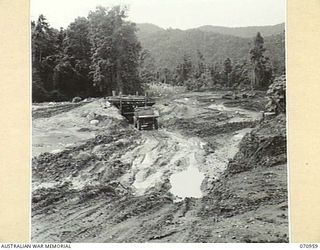 ZENASG, NEW GUINEA, 1944-02-27. GRAVEL AT A PIT FIFTY SIX AND THREE QUARTER MILES FROM WAU, DISCOVERED DURING LATRINE EXCAVATIONS. TO DATE 9,000 CUBIC YARDS OF GRAVEL HAVE BEEN EXCAVATED