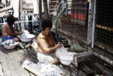 Papua New Guinea, women doing laundry on deck of stilt house