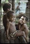 Children playing on a house veranda, Imala wearing a red shell necklace