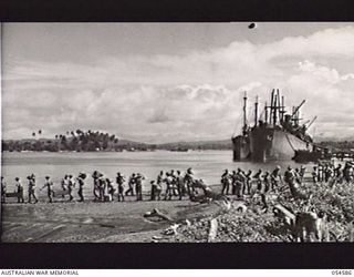 GILI GILI, NEW GUINEA, 1943-07-15. TROOPS OF THE 29TH AUSTRALIAN INFANTRY BRIGADE, 5TH AUSTRALIAN DIVISION, LOADING STORES BY "ROUND ROBIN" PRIOR TO EMBARKING ON AMERICAN LCI'S (LANDING CRAFT ..