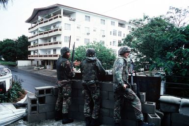 Three Marines man a security post overlooking a road outside the United States Embassy. Marines of the 22nd Marine Expeditionary Unit (22nd MEU), deployed aboard the amphibious assault ship USS SAIPAN (LHA 2), were sent to augment security at the embassy as part of Operation SHARP EDGE