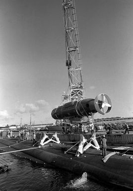 A crane lowers the deep submergence rescue vehicle AVALON (DSRV-2) onto pylons attached to the hull of the nuclear-powered attack submarine USS CAVALLA (SSN-684). The AVALON and CAVALLA are taking part in a fly-away exercise to train personnel in the handling and operation of the DSRV