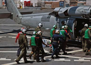 U.S. Navy Military Sealift Command Mercy Class Hospital Ship USNS MERCY (T-AH 19) flight deck personnel carry a litter borne patient to a waiting Helicopter Sea Combat Squadron 25 (HSC-25, ΦIsland Knightsτ) MH-60S Knight Hawk (Sierra) helicopter for a return trip back to the city of Dili, East Timor, Indonesia, on Aug. 29, 2006. HSC-25 is from Guam and has helped transport U.S. medical personnel and Indonesian patients to and from the sip, while the MERCY is in the fourth month of a five-month humanitarian and civic assistance deployment to Southeast Asia. (U.S. Navy photo by Mass Communication SPECIALIST SEAMAN Mike Leporati) (RELEASED)