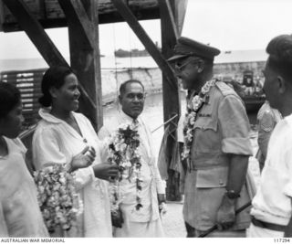 NAURU ISLAND. 1945-09-15. BRIGADIER J. R. STEVENSON DSO, COMMANDING 11TH AUSTRALIAN INFANTRY BRIGADE BEING GIVEN A LEI OF FLOWERS BY THE WIFE OF A NATIVE CHIEF ON HIS ARRIVAL ON THE ISLAND TO TAKE ..