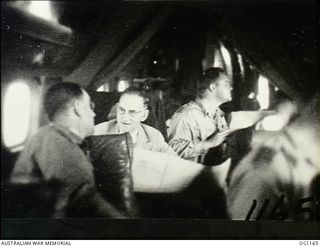 IN FLIGHT BETWEEN HOLLANDIA, DUTCH NEW GUINEA AND AITAPE, NORTH EAST NEW GUINEA. C. 1944-06. INTERIOR OF AIRCRAFT CARRYING ARTHUR DRAKEFORD (SECOND FROM LEFT), THE MINISTER FOR AIR, AND HIS PARTY ..