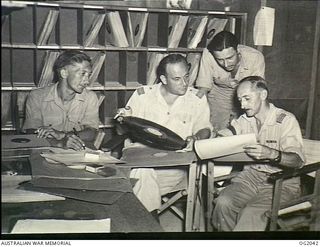 MADANG, NEW GUINEA. C. 1944. STAFF AT RAAF RADIO MADANG CHECKING SOUND RECORDINGS TO COMPILE THE WEEKLY PROGRAMME, A WEEK IN ADVANCE. LEFT TO RIGHT: 437609 LEADING AIRCRAFTMAN K. D. ROBINSON, WEST ..