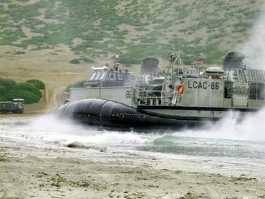 A Landing Craft, Air Cushioned (LCAC) assigned to the amphibious assault ship USS SAIPAN (LHA 2) lands on Red Beach on Sardinia, Italy