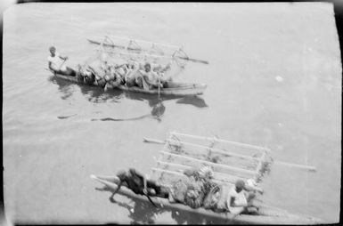 Two outrigger canoes laden with produce with women as crew, Rabaul, New Guinea, ca. 1929 / Sarah Chinnery