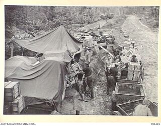 SOUTH BOUGAINVILLE. 1945-07-29. TROOPS OF 29 INFANTRY BRIGADE LOADING A TRACTOR TRAIN WITH ORDNANCE STORES FROM A DUMP BESIDE THE THREE TONNER SECTION OF THE BUIN ROAD. STORES ARE TRANSPORTED FROM ..