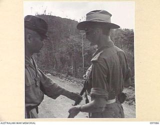 MOUNT SHIBURANGU, WEWAK AREA, NEW GUINEA. 1945-09-21. JAPANESE OFFICER OF 18 JAPANESE ARMY HANDING HIS SWORD TO CAPTAIN M.B. LONG, HEADQUARTERS 6 DIVISION, AT A CONTROLLING POINT AT MAKOW ON THE ..