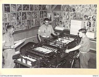 LAE AREA, NEW GUINEA. 1945-08-31. SERGEANT D.S. PARSONS, ENGINEER (CENTRE), WITH MACHINISTS WHO ARE OPERATING A MILLER PRESS DURING THE PRODUCTION OF THE ARMY NEWSPAPER, GUINEA GOLD AT "CHARING ..
