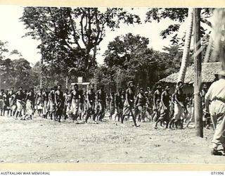 LAE, NEW GUINEA. 1944-04-01. NATIVES FROM THE AUSTRALIAN NEW GUINEA ADMINISTRATIVE UNIT LEAVE A PARADE AFTER THE PRESENTATION OF MEDALS FOR BRAVERY BY MAJOR GENERAL B.M. MORRIS, DSO, GENERAL ..