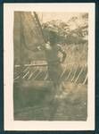 Don Honeysett standing in front of traditional thatched building, New Guinea, c1929 to 1932