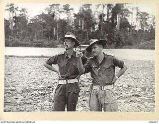 TOL AREA, NEW BRITAIN. 1945-08-01. OFFICERS OF 4 FIELD COMPANY, ROYAL AUSTRALIAN ENGINEERS, INSPECTING DAMAGE TO THE BRIDGE OVER THE WULWUT RIVER. IDENTIFIED PERSONNEL ARE:- LIEUTENANT COLONEL H.B. ..