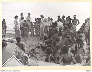 RABAUL, NEW BRITAIN. 1945-11-04. AUSTRALIAN ARMY MEDICAL WOMEN'S SERVICE PERSONNEL FROM 118 GENERAL HOSPITAL FULLY OCCUPIED WITH NATIVE CHILDREN ON THE SHORE OF SIMPSON HARBOUR