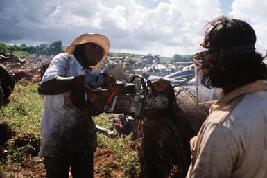 A worker takes a power cutter to the wheel of the remains of a B-52D Stratofortress aircraft, one of three that are being scrapped in accordance with the SALT II treaty between the United States and the Soviet Union