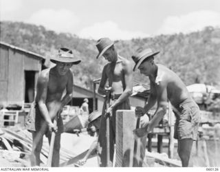 NAPA NAPA, NEW GUINEA. 1943-11-12. TROOPS OF THE 18TH AUSTRALIAN FIELD COMPANY, ROYAL AUSTRALIAN ENGINEERS INSTALLING A HOLDFAST FOR CONSTRUCTION WORK AT THE WORKSHOPS OF THE 2ND AUSTRALIAN ..