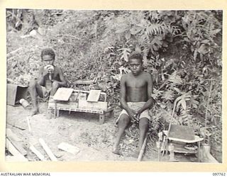 RABAUL, NEW BRITAIN. 1945-10-04. A CRIPPLED NATIVE LAD WHO BUILDS MINIATURE VILLAGES AT PRAED POINT TO PASS THE TIME AWAY