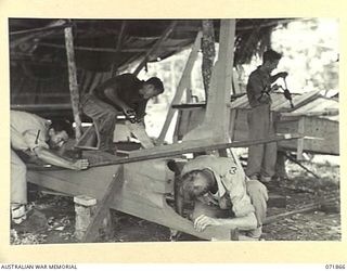 LAE, NEW GUINEA. 1944-03-30. PERSONNEL OF THE 2ND MARINE FOOD SUPPLY PLATOON BUILDING SKIFFS EIGHTEEN FEET IN LENGTH USED TO NET FISH FOR THE HOSPITALS. LEFT TO RIGHT: Q24263 SERGEANT S. C. ..