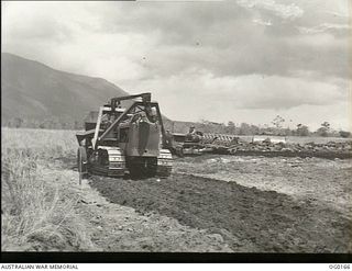 VIVIGANI, GOODENOUGH ISLAND, PAPUA NEW GUINEA. 1943-09-23. GUINEA. 1943-09-23. AIRMEN AND MACHINERY OF NO. 7 MOBILE WORKS SQUADRON RAAF CONSTRUCTING A DISPERSAL BAY, ONE OF THE MANY JOBS IN MAKING ..