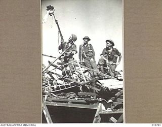 1943-09-22. NEW GUINEA. AUSTRALIAN TROOPS CAPTURE LAE. AUSTRALIANS SURVEY THE CAPTURED FLAG FROM THE TOP OF WHAT WAS ONCE THE RESIDENCE OF THE JAPANESE COMMANDING OFFICER