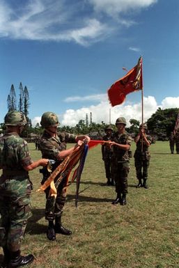 Lieutenant Colonel Myrt W. Webb Jr., commander of the 1ST Battalion, 8th Field Artillery, attaches battle streamers to the 8th Field Artillery Regimental Flag, while Command Sergeant Major Graham A. Simmons holds the staff. The 3rd Battalion, 13th Field A