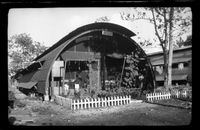 [Quonset hut with garden and small picket fence]