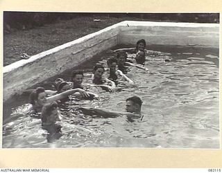 LAE, NEW GUINEA. 1944-10-31. CORPORAL E.L. BUCKMAN (1), INSTRUCTING NURSES AND MEMBERS OF THE ARMY MEDICAL WOMEN'S SERVICE IN SWIMMING AT THE AUSTRALIAN NEW GUINEA ADMINISTRATIVE UNIT POOL. LESSONS ..