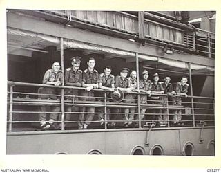 THE WHARF, JACQUINOT BAY, NEW BRITAIN, 1945-08-13. HEADQUARTERS 5 DIVISION OFFICERS LINE THE DECK OF THE TROOPSHIP VAN OUTHOORN BEFORE SAILING FOR AUSTRALIA