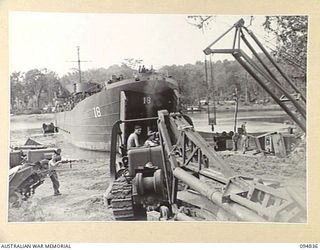 JACQUINOT BAY, NEW BRITAIN, 1945-08-08. PERSONNEL OF 41 LANDING CRAFT COMPANY MOVING HEAVY GEAR ONTO A LANDING SHIP, TANK (LST) FOR MOVEMENT TO BORNEO. THE LE TOURNEAU CRANE IN TOP RIGHT FOREGROUND ..