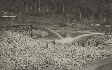 Hydraulic sluicing with monitors and elevator, on the site of a pioneer claim on the Bulolo river, the one time property of Messrs Arnold & Robertson and now a section of Bulolo Gold dredging coys areas