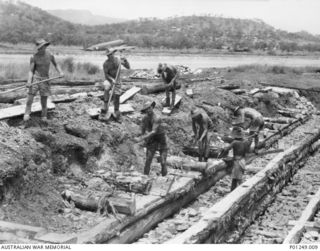 WARDS STRIP, PORT MORESBY, NEW GUINEA, 1943-03. MEMBERS OF THE RAAF AT WORK BUILDING A DRAIN, USING SAWN TIMBERS WITH ROCK FILL, BESIDE A RUNWAY. WARDS AERODROME WAS WORKED ON BY BOTH NO. 2 AND NO. ..