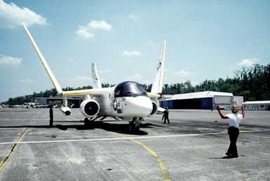 A ground crew member signals to the pilot of a Fleet Logistics Support Squadron 50 (VRC-50) S-3A Viking aircraft as it is positioned on the flight line. The squadron will be relocating to Andersen Air Force Base, Guam, following closure of NAS, Cubi Point and Naval Station, Subic Bay. Control of the instrallations will be assumed by the Subic Bay Metropolitian Authority