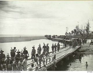 BOUGAINVILLE ISLAND. 1944-12-06. TROOPS OF A COMPANY, 15TH INFANTRY BATTALION WALKING ACROSS THE BRIDGE OVER THE TOROKINA RIVER AS THEY PROCEED TO THE FORWARD AREAS TO RELIEVE PERSONNEL OF THE 1ST ..