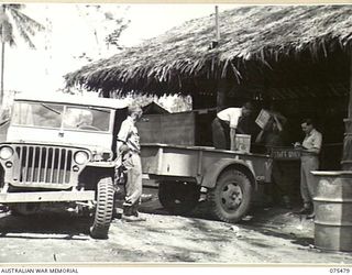 LAE, NEW GUINEA. 1944-08-27. PERSONNEL OF THE AUSTRALIAN COMFORTS FUND HEADQUARTERS LOADING COMFORTS IN TO A JEEP AND TRAILER FOR DELIVERY TO THE UNITS IN THE AREA. IDENTIFIED PERSONNEL ARE:- ..